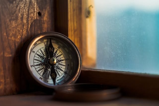 A compass next to a window.