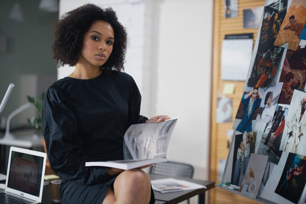 a young woman sitting next to the fashion photos she made